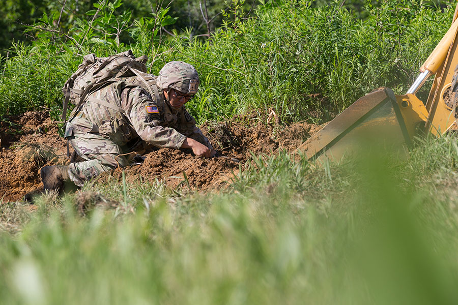 Explosive disposal team leader uncovers a simulated explosive device. 