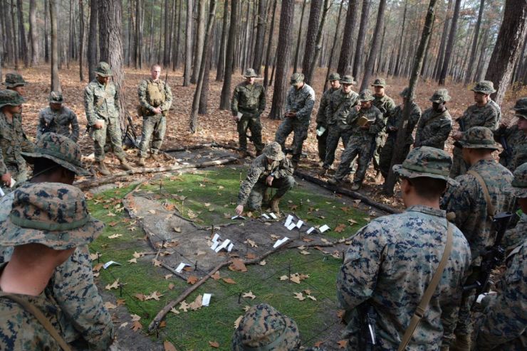USMC warriors planning attack in a sand box. 