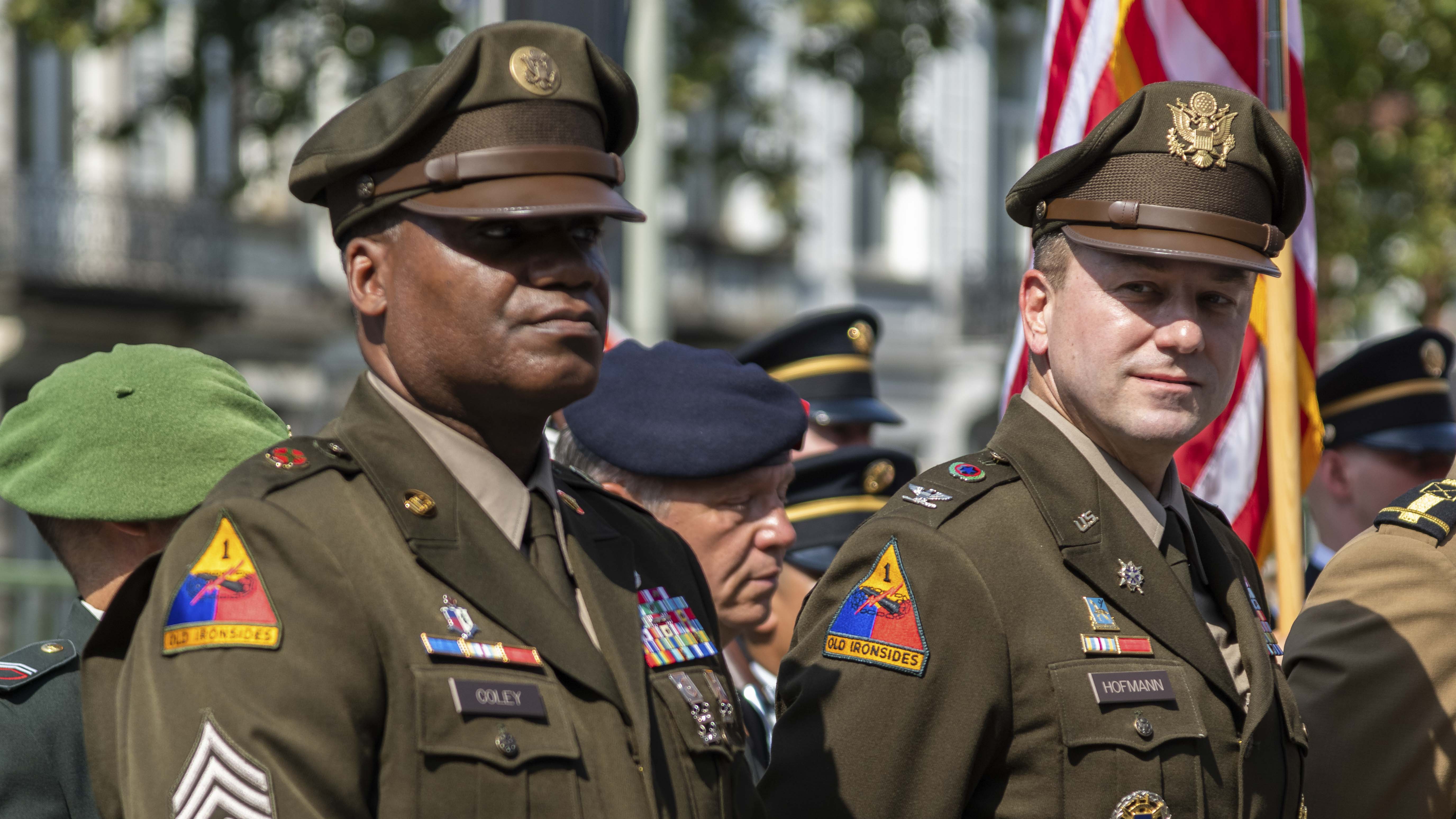 A photograph of a line of Soldiers saluting 