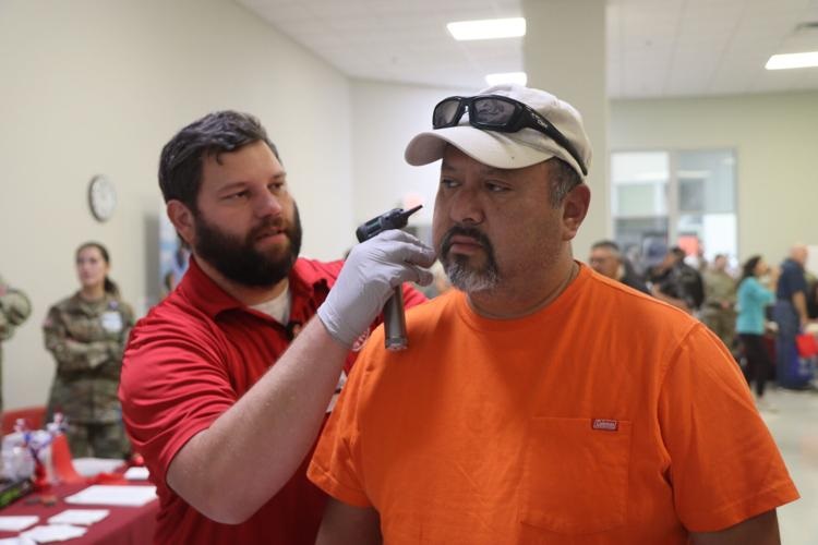 Retired Staff Sgt. Nery Ortiz receives a free ear examination from Keith Chumley, lead hearing technician, Blanchfield Army Community Hospital, Oct. 1, 2022 at the Soldier Support Center during Fort Campbell's annual Retiree Appreciation Day. BACH brings a health fair to the event each year, providing retirees with immunizations and other health care resources.
