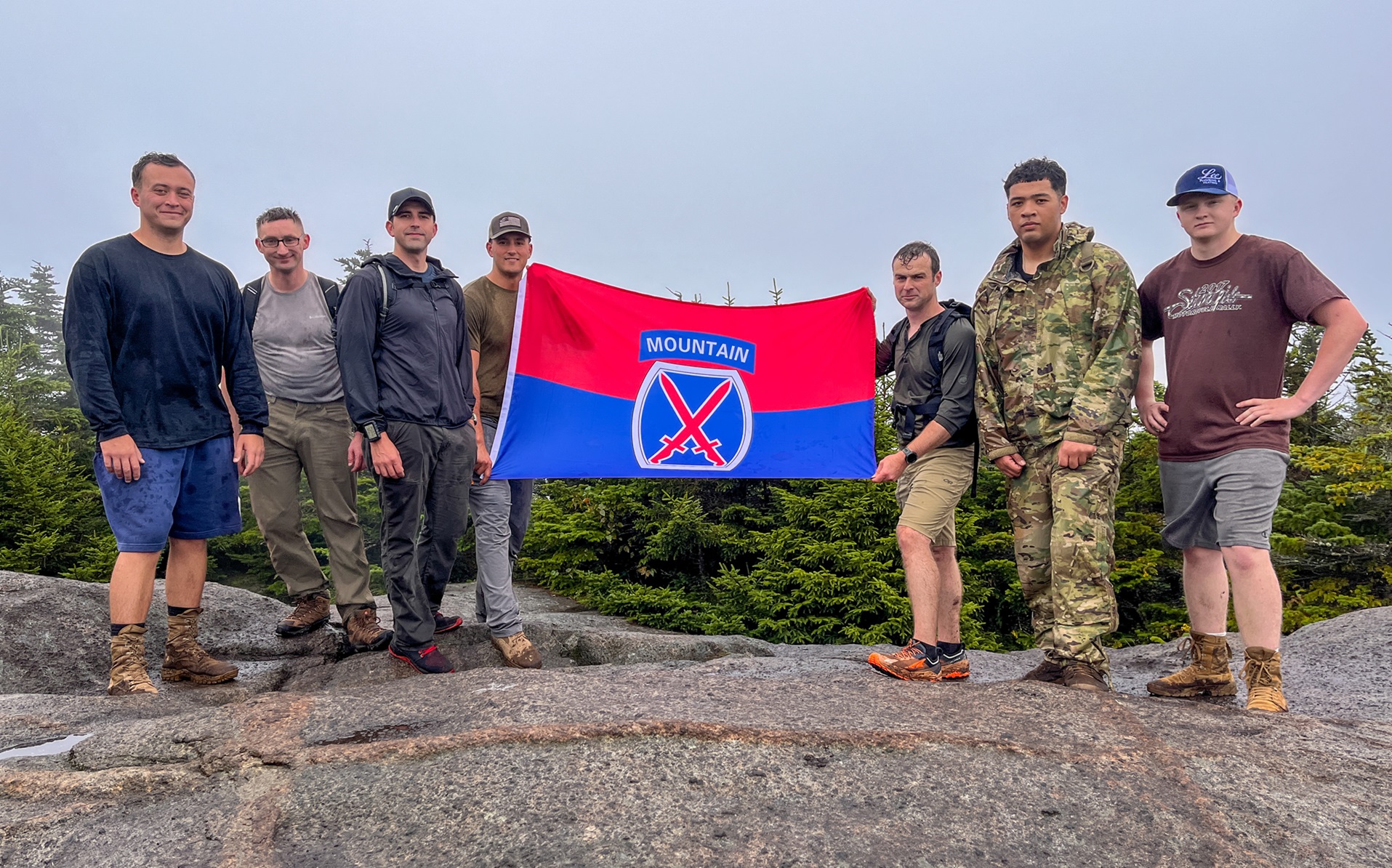 Soldiers display 10th Mountain flag after reaching summit of Porter Mountain.