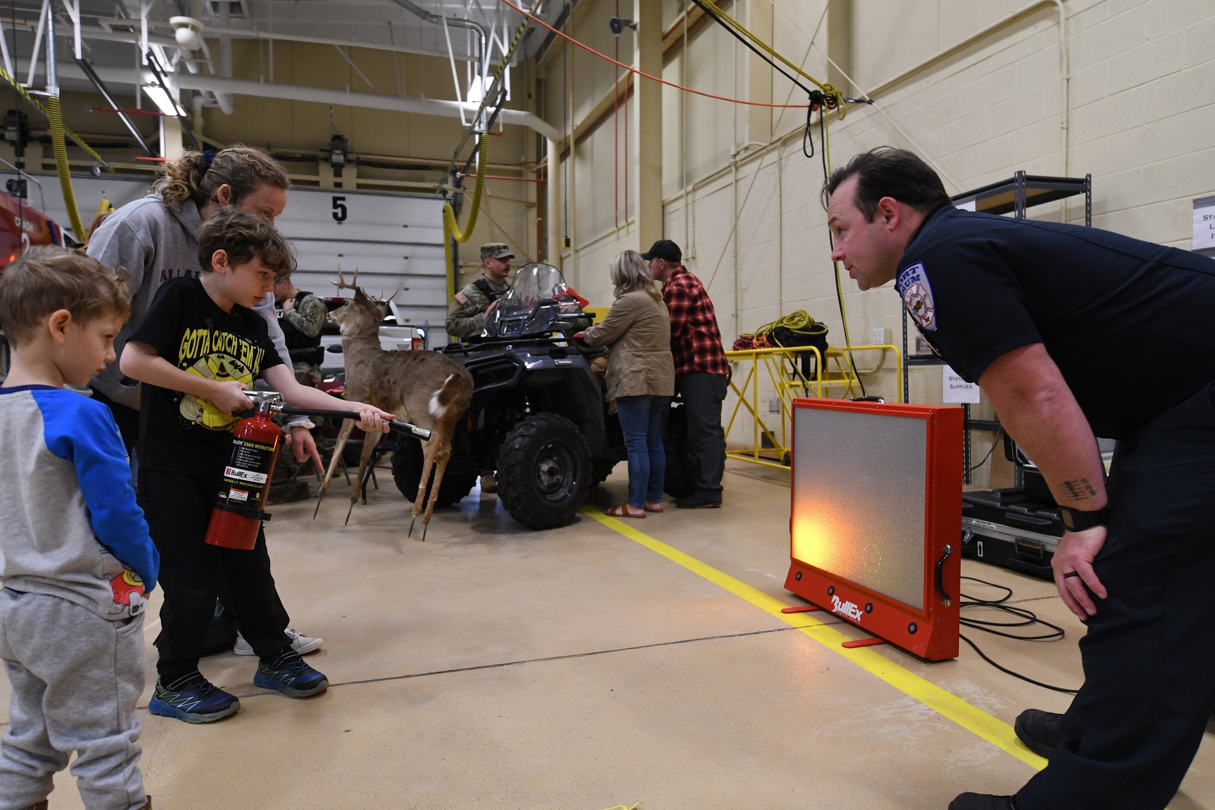 Boy tries out a simulated fire extinguisher during the Fort Drum Fire Department Open House..