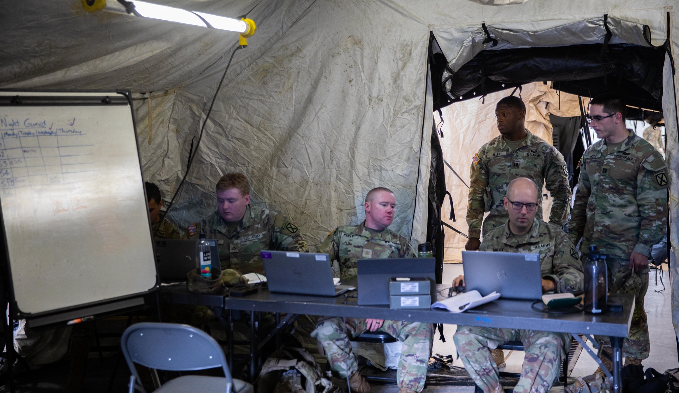 Soldiers initiate command node operations insite an Army tent.