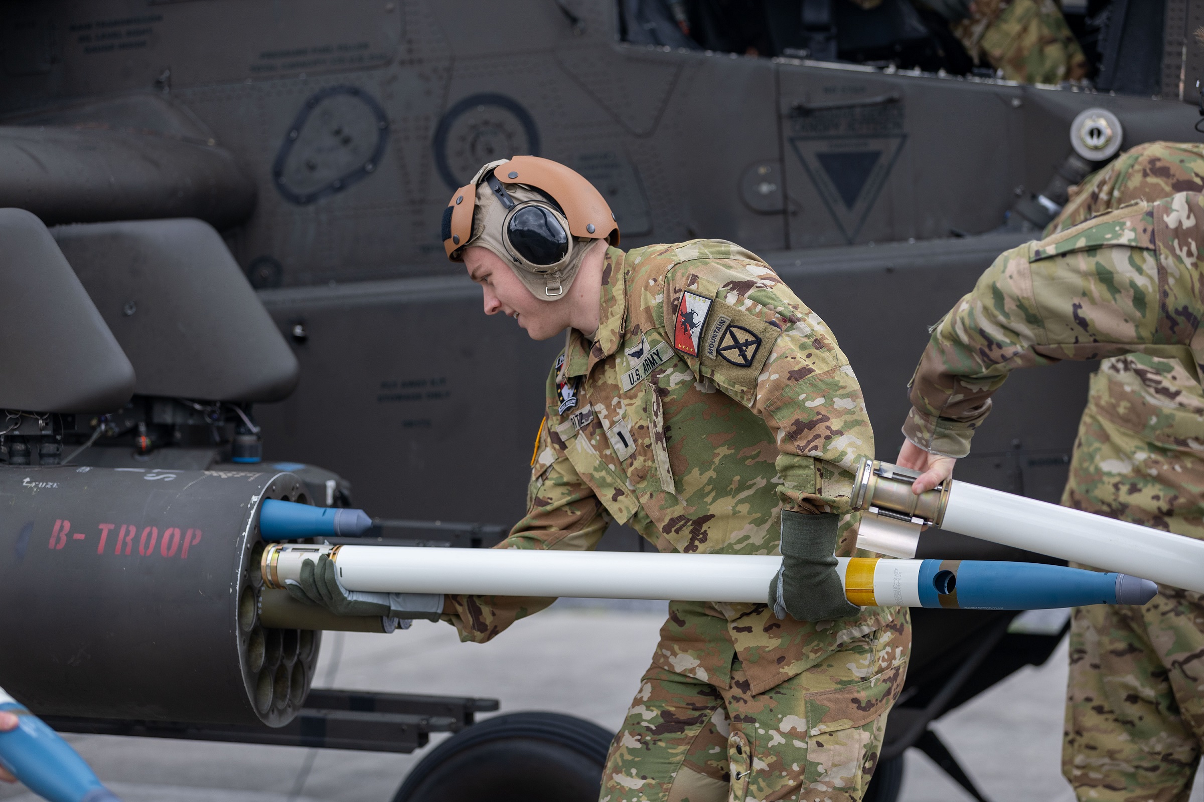 Soldier loads ammunition into helicopter.