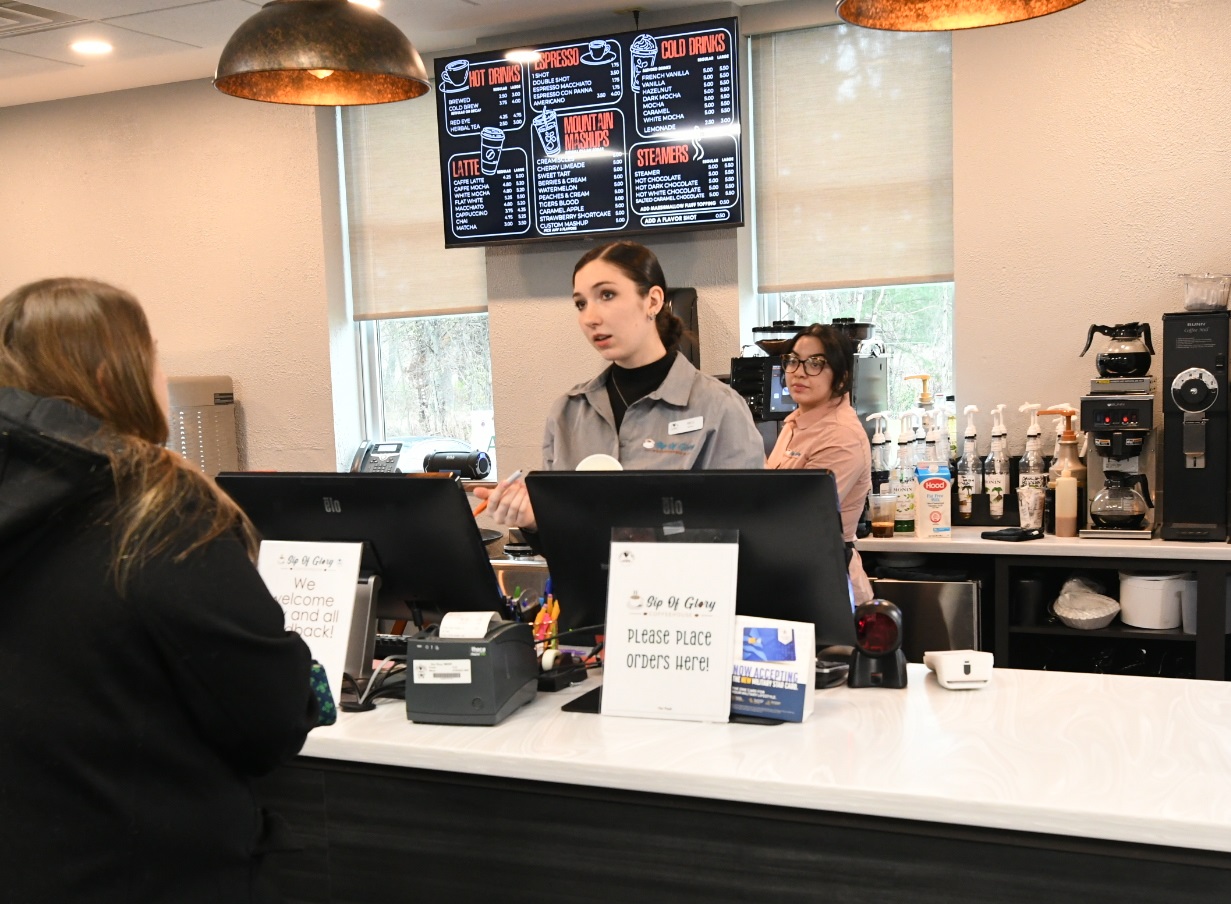 Barista takes customer's order inside new coffeehouse on Fort Drum.