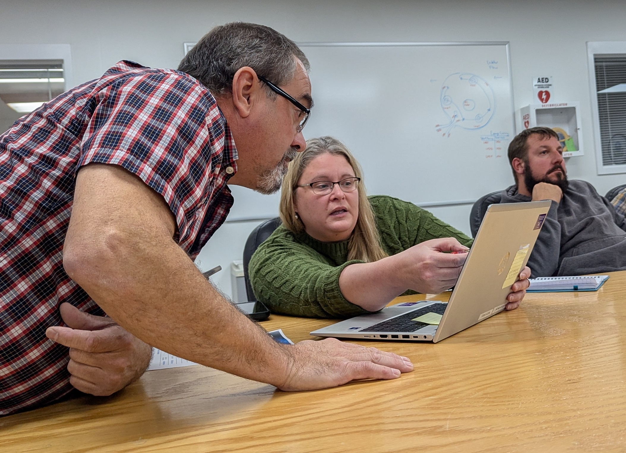 Man and woman confer over a laptop computer during a tabletop exercise.