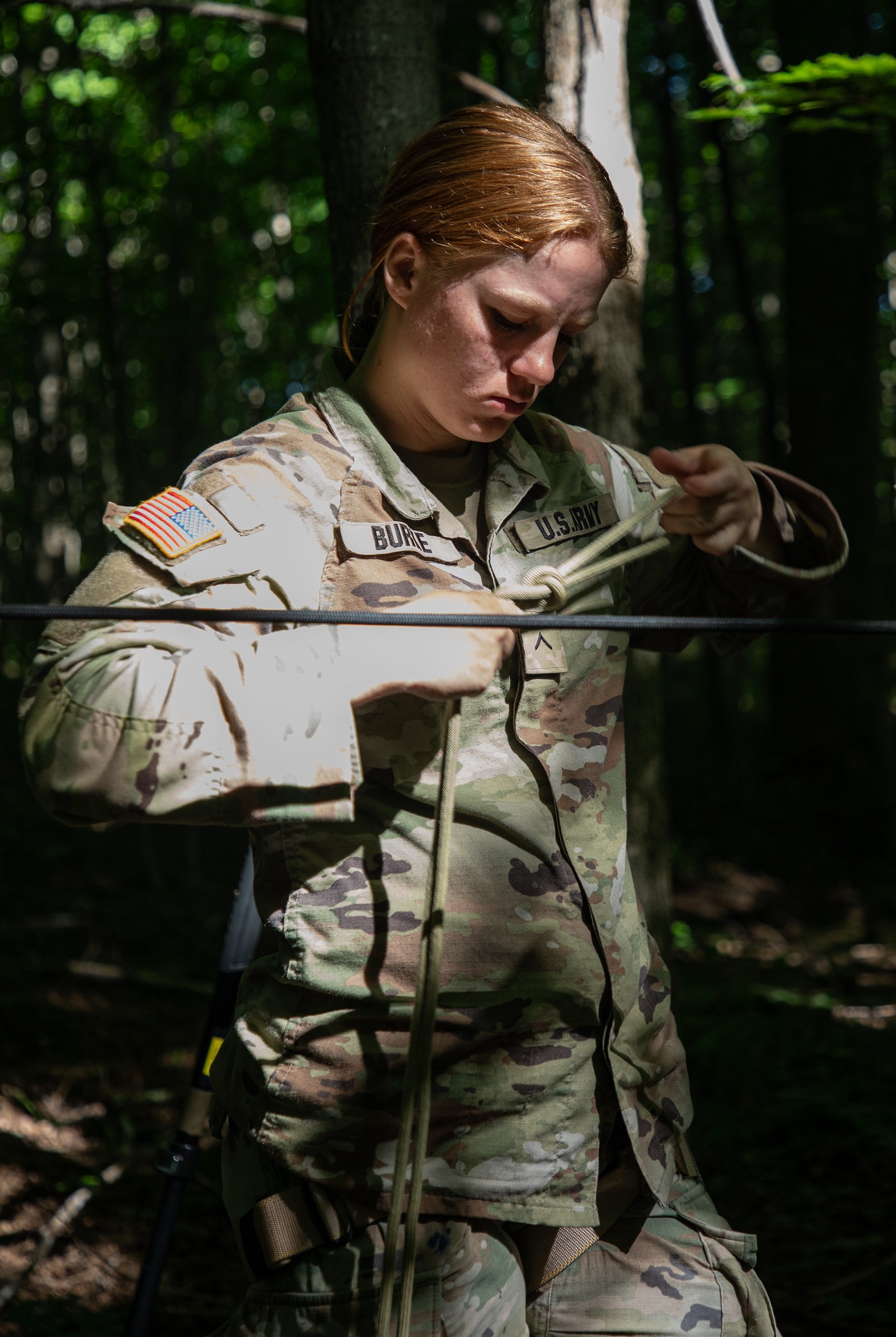 Female Soldier learns to properly tie a rope for rappeling.