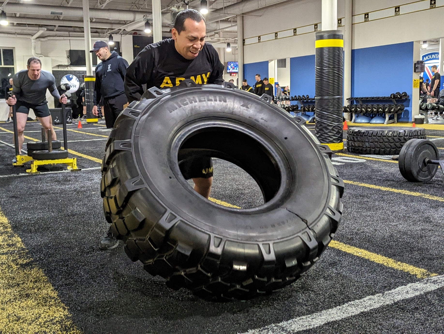 Soldier flips large tire during Atkins Challenge inside Atkins FFF.