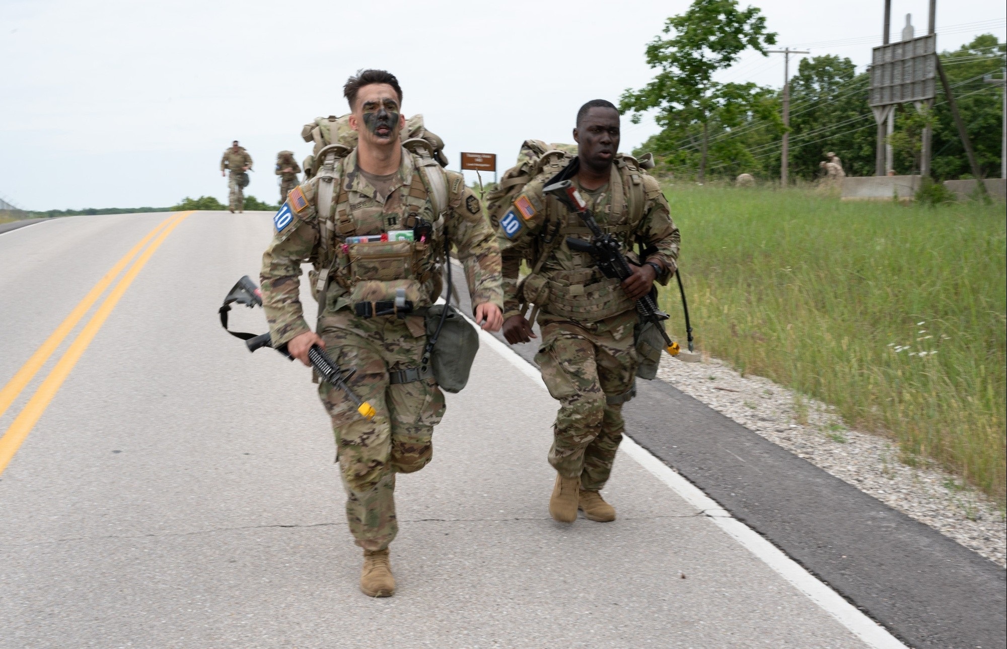 Two Soldiers participate in ruck march.
