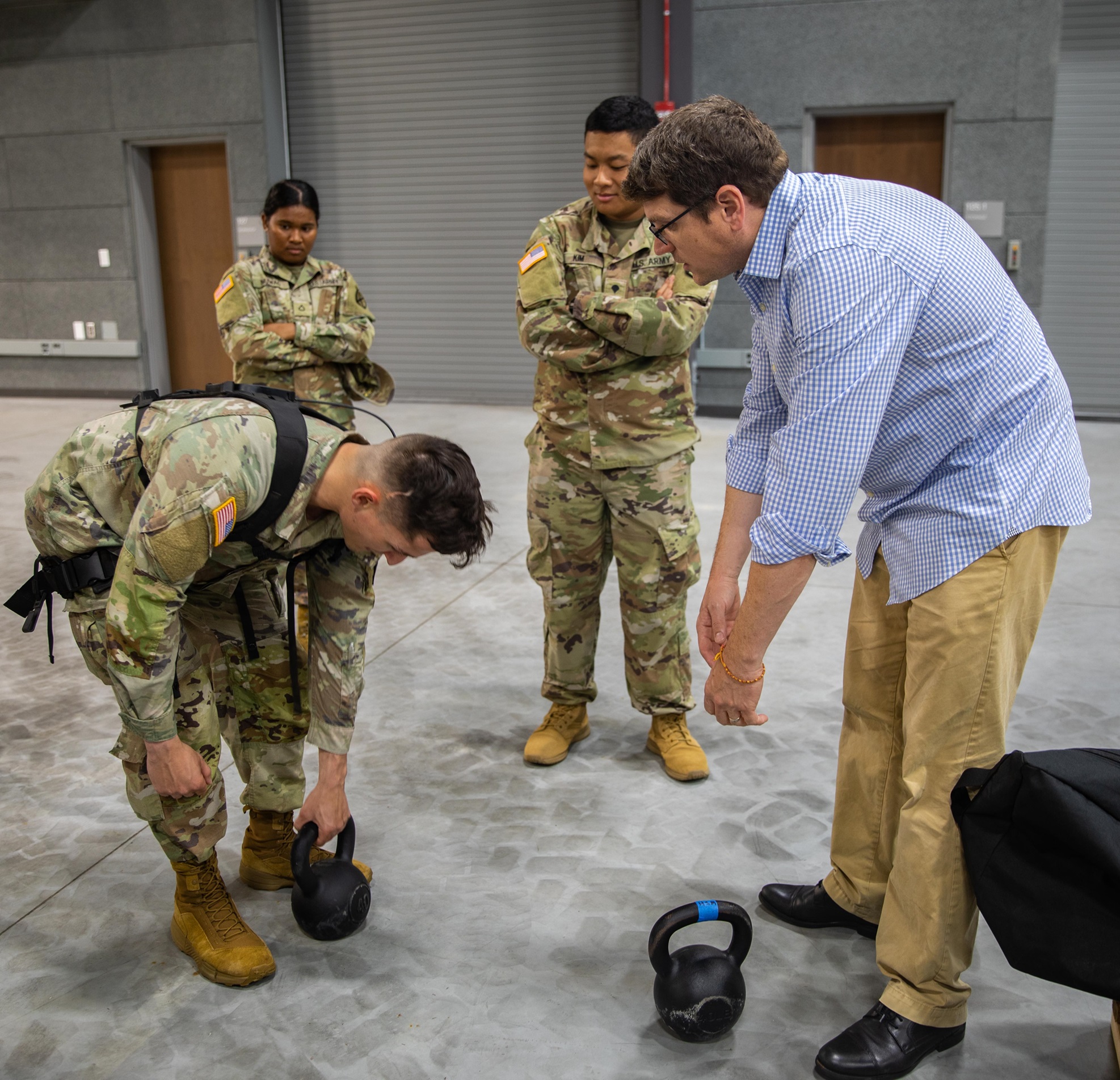 Soldier tries lifting weight using exoskeleton system.