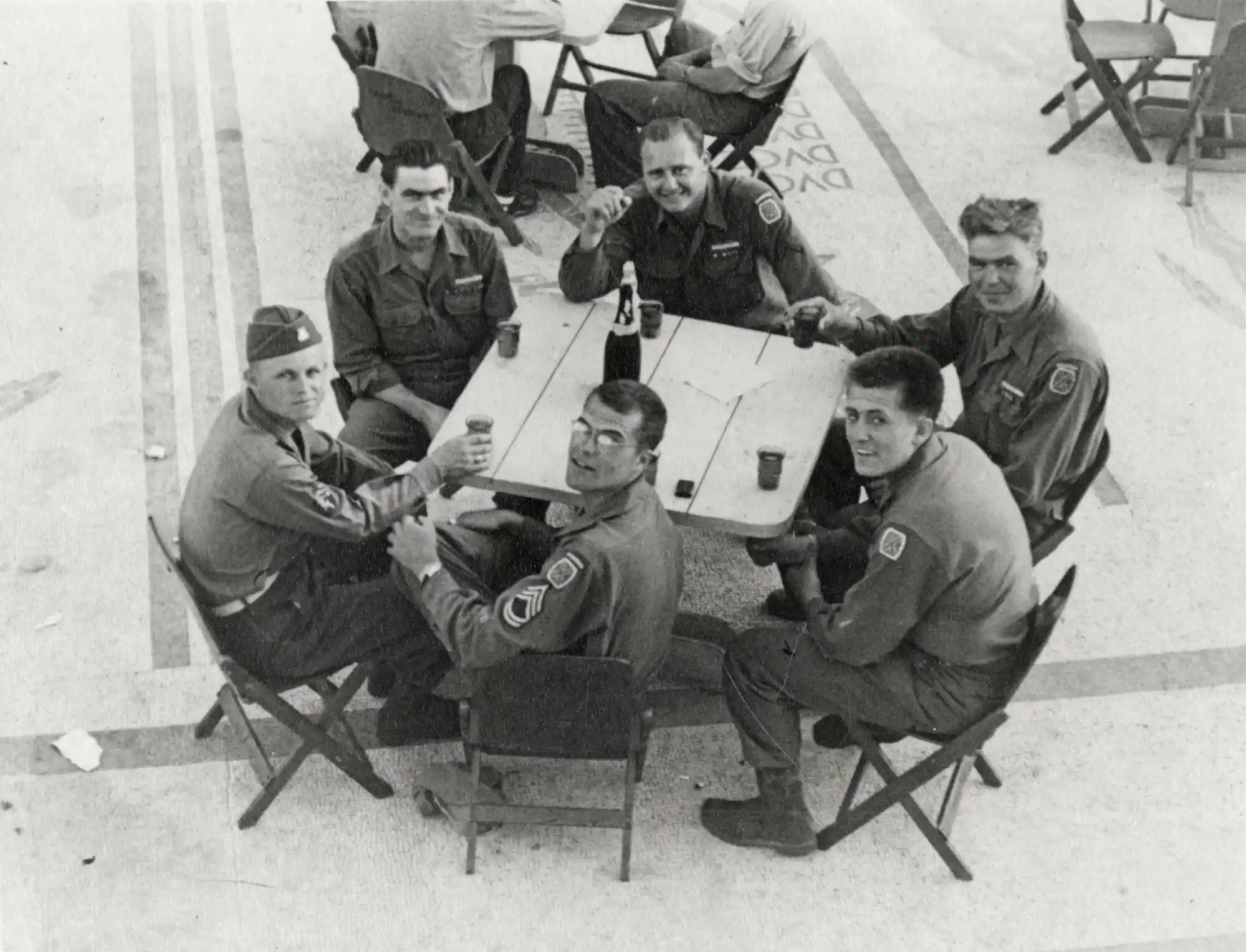 Soldiers sit outside at tables near Mussolinis Villa