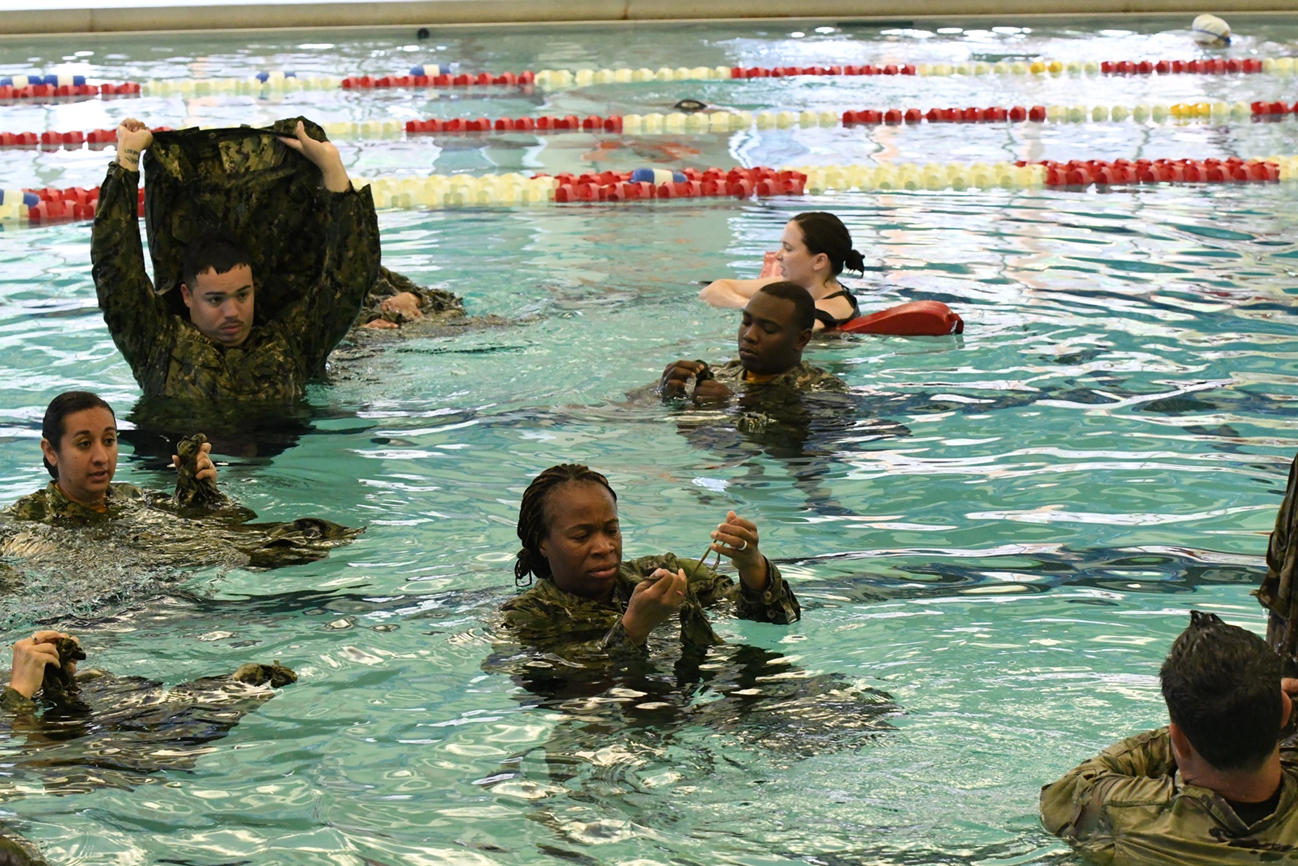 Navy Reservists practice water survival skills in a pool at Fort Drum.