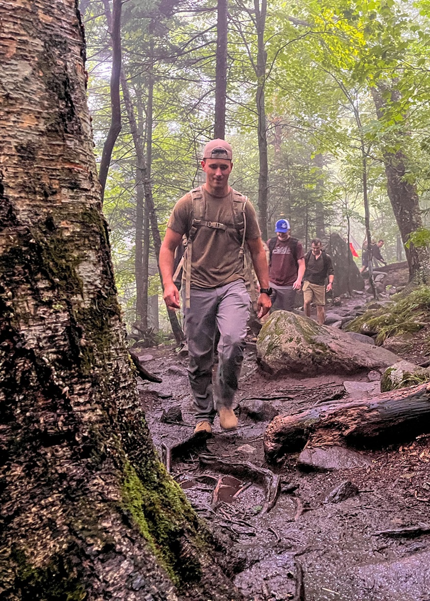 Officer leads team through woods while climing Porter Mountain.