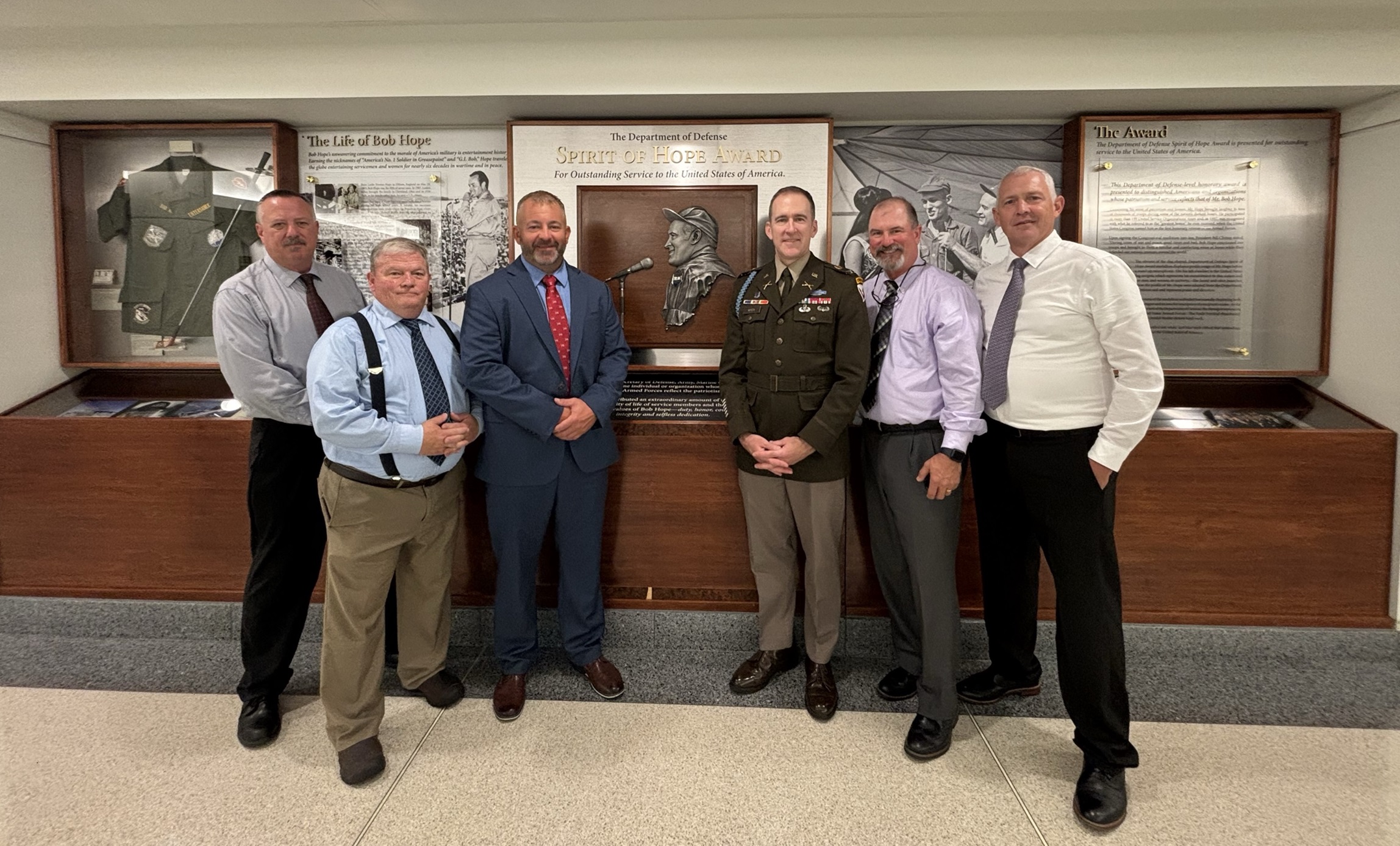 Fort Drum garrison commander stands with members of North Country Troopers Assisting Troops who won the Spirit of Hope Award.