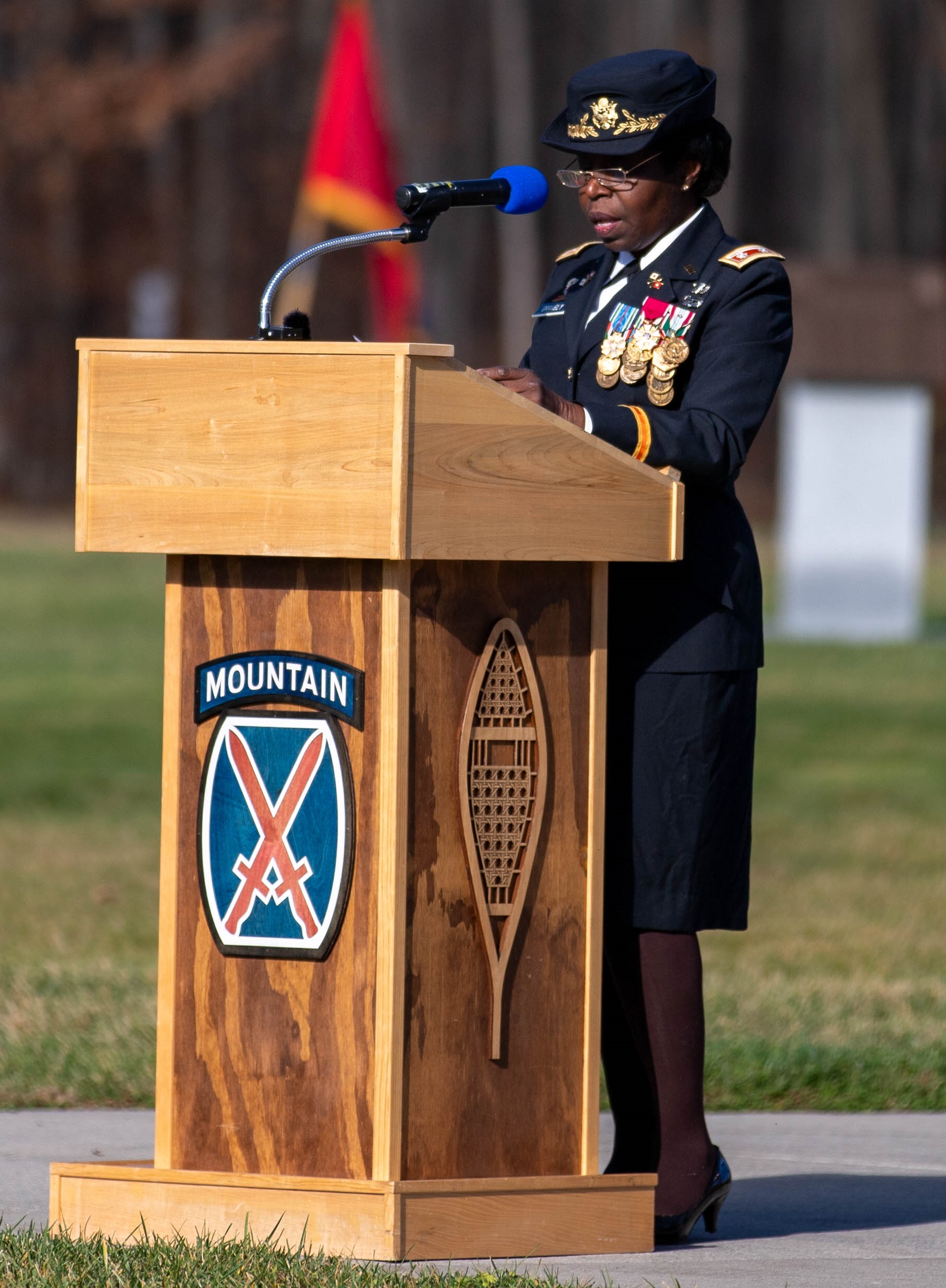 Femal Soldier addresses audience during 2024 Veterans Day ceremony in Memorial Park on Fort Drum.