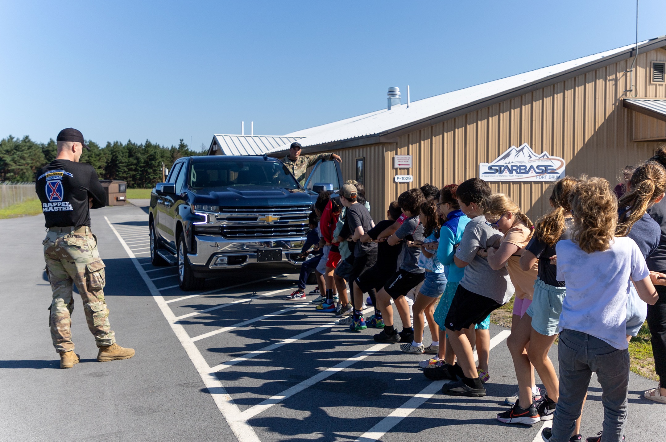 Students help to pull a pickup truck at STARBASE summer camp.