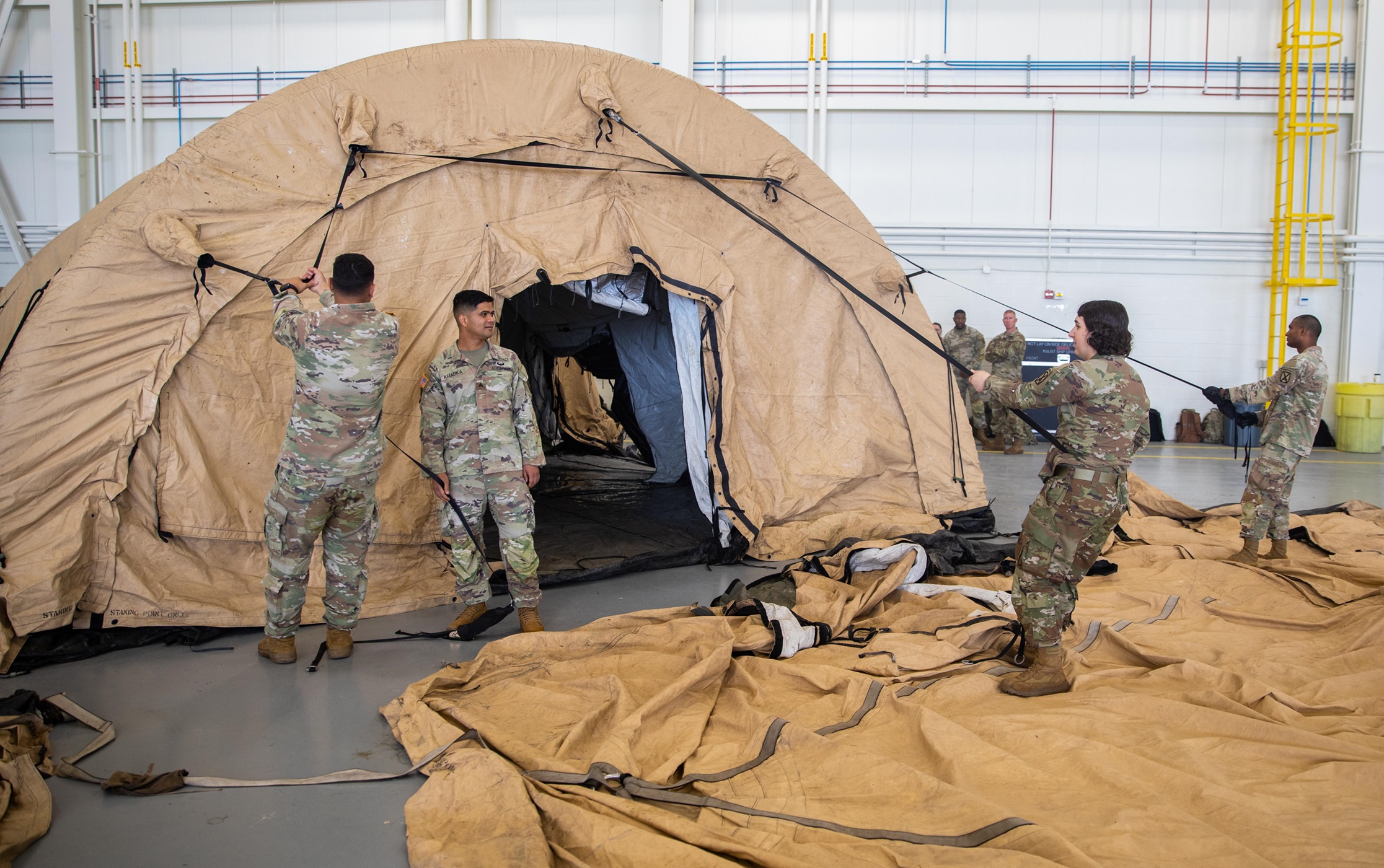 Soldiers set up a tent as part of a command node.