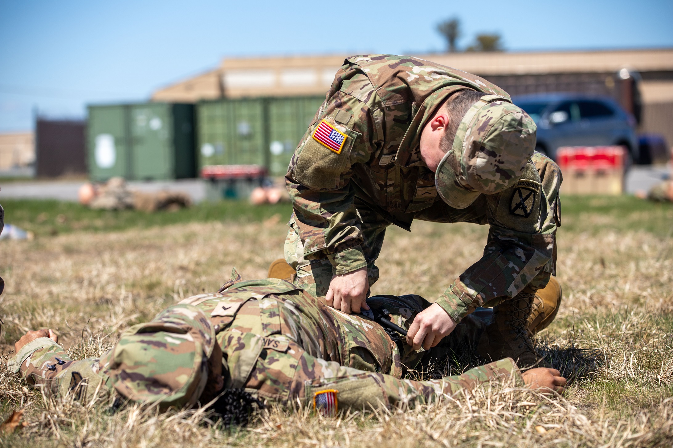 Soldier applies tourniquet to leg of fellow Soldier