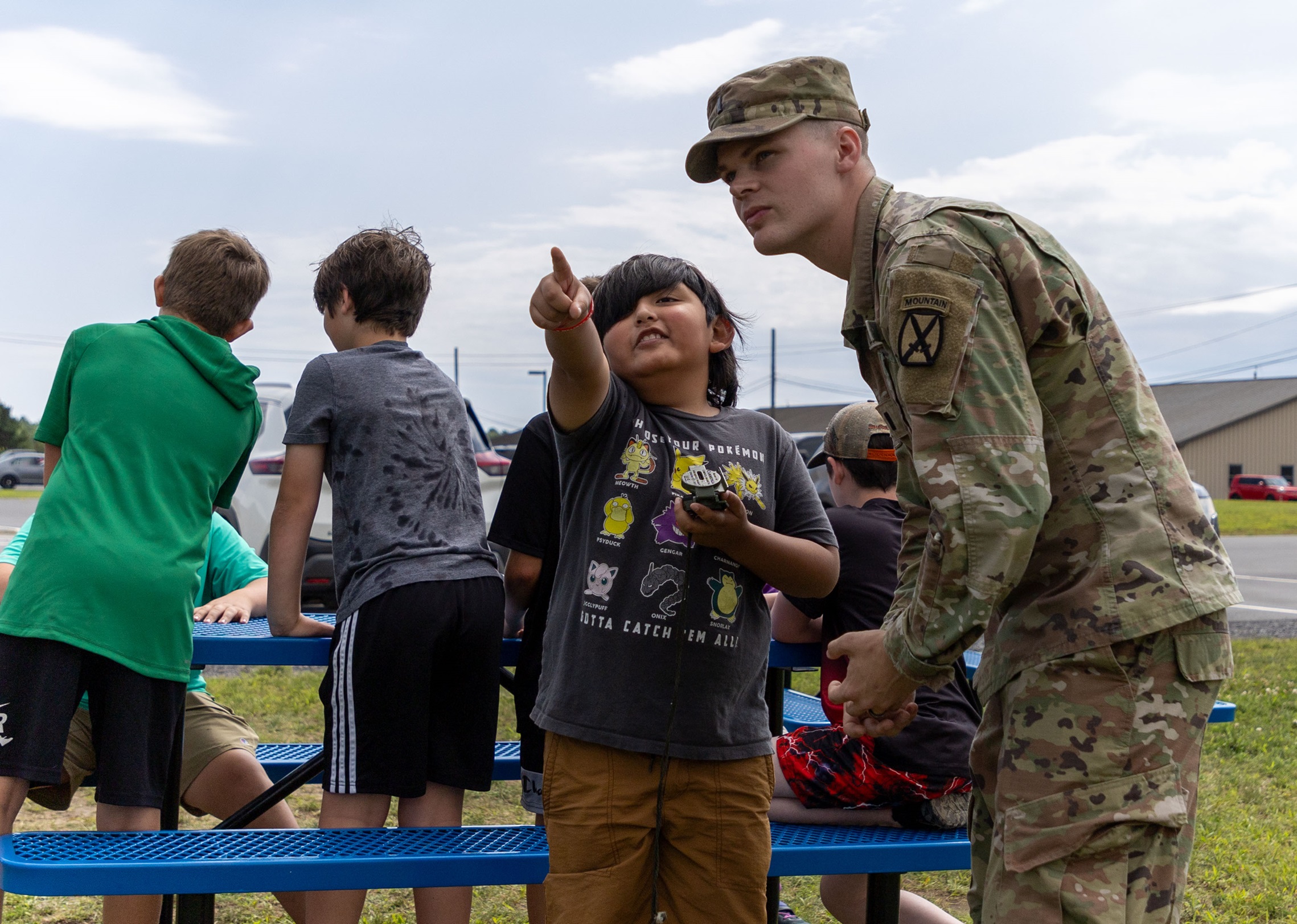 Soldier teaches student about using a compass at STARBASE summer camp.