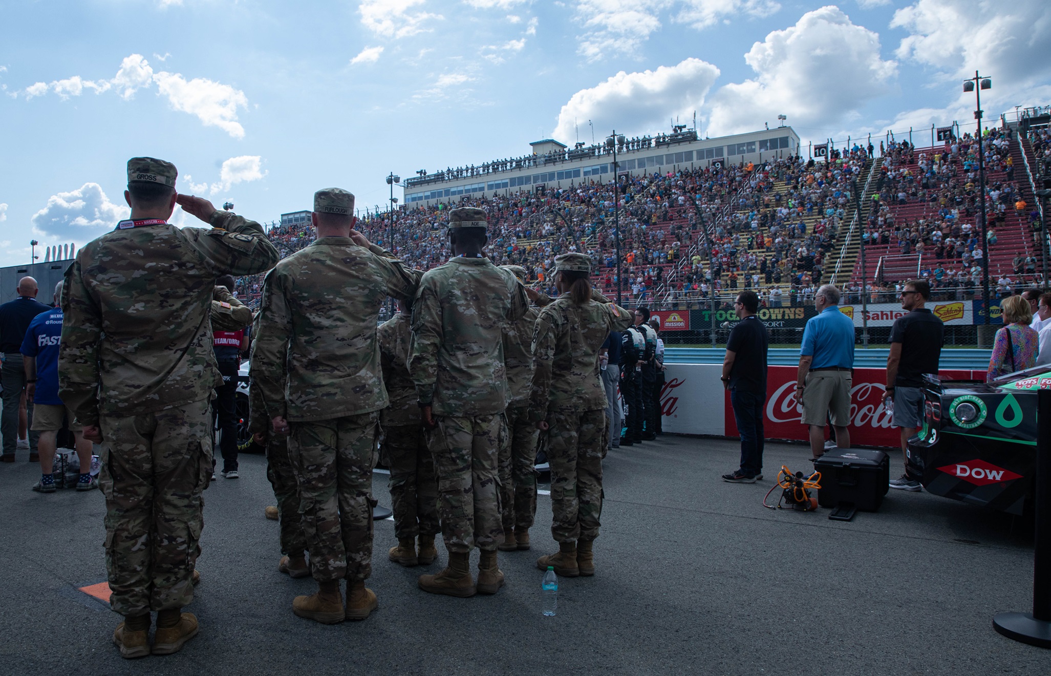 Soldiers salute the flag during the national anthem on pit road at Watkins Glen International.