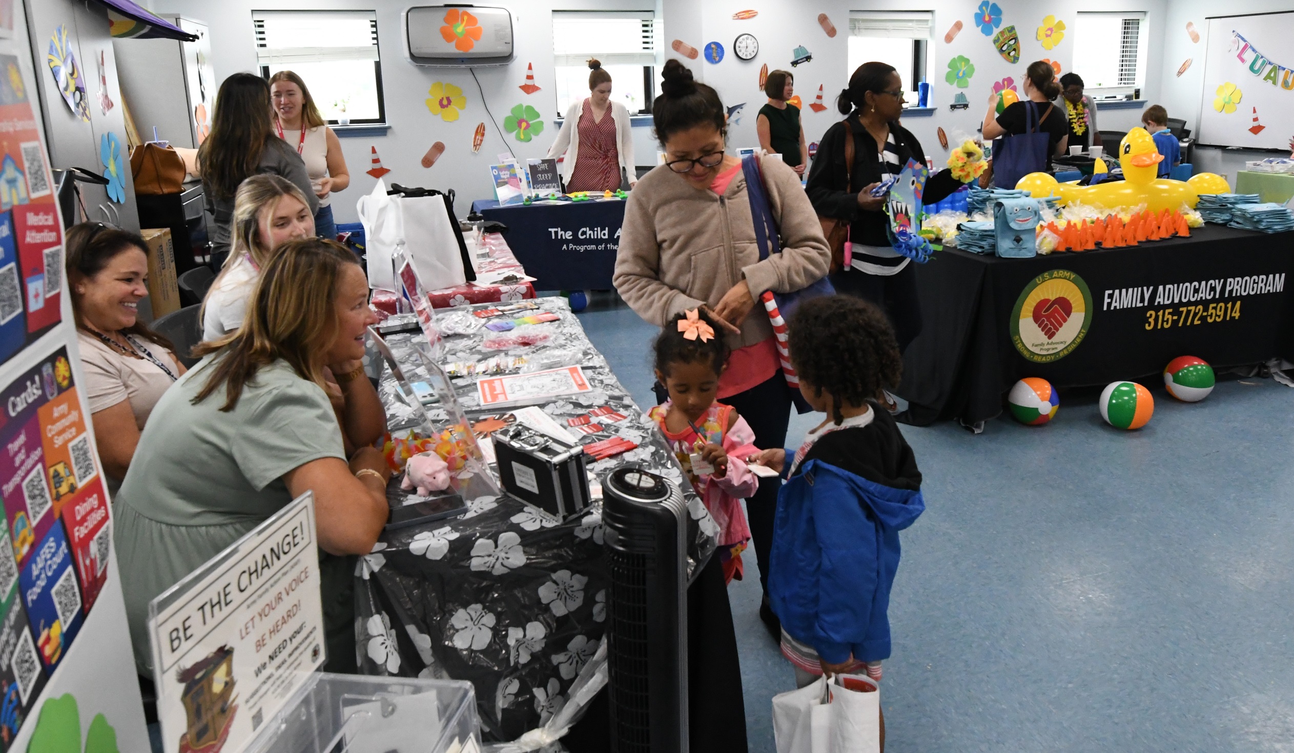 Families visit with staff member at tables during the 2024 FAP Safety Luau.