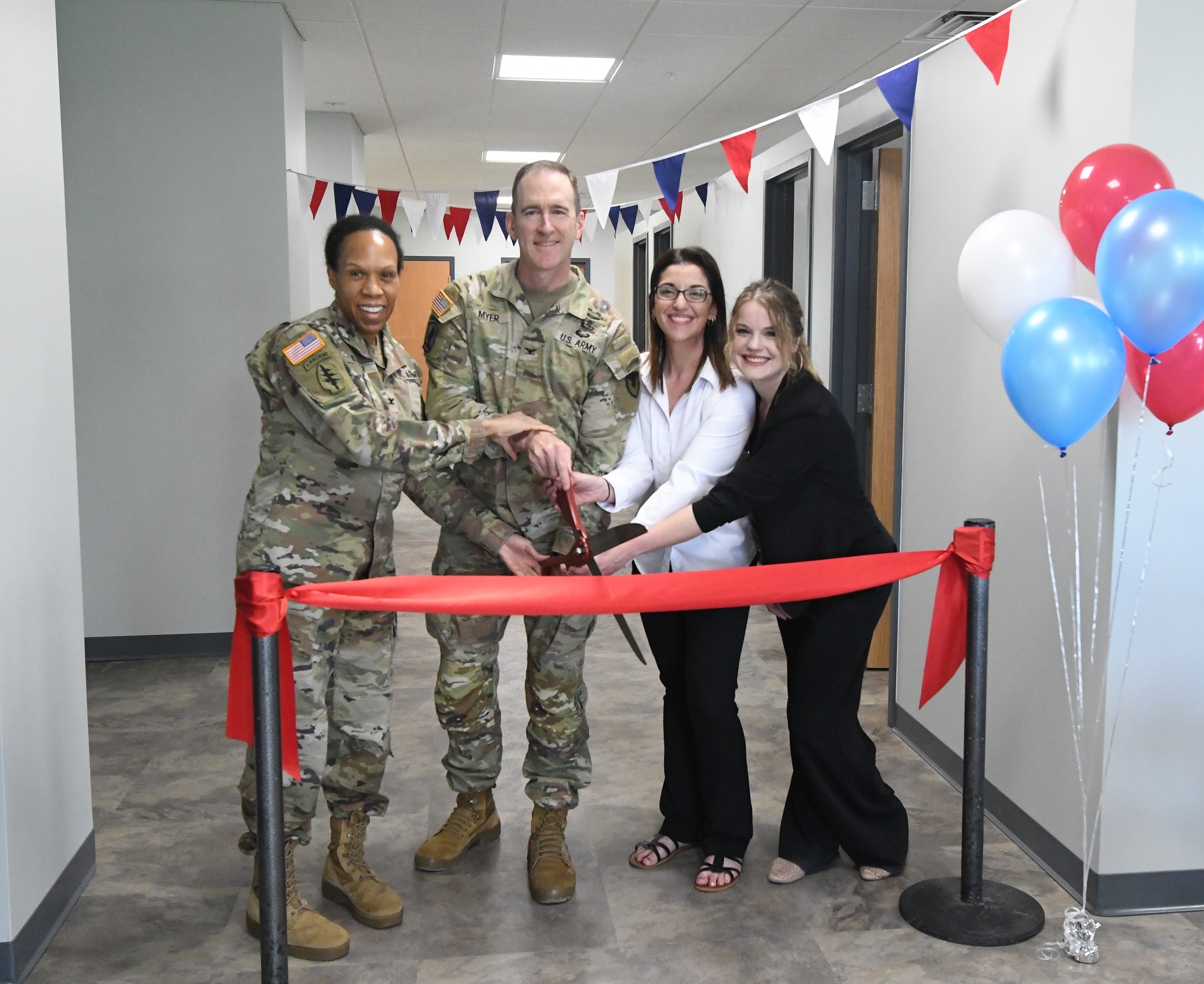 Two Soldiers - two civilians cut ribbon at new Fort Drum SRP Center.