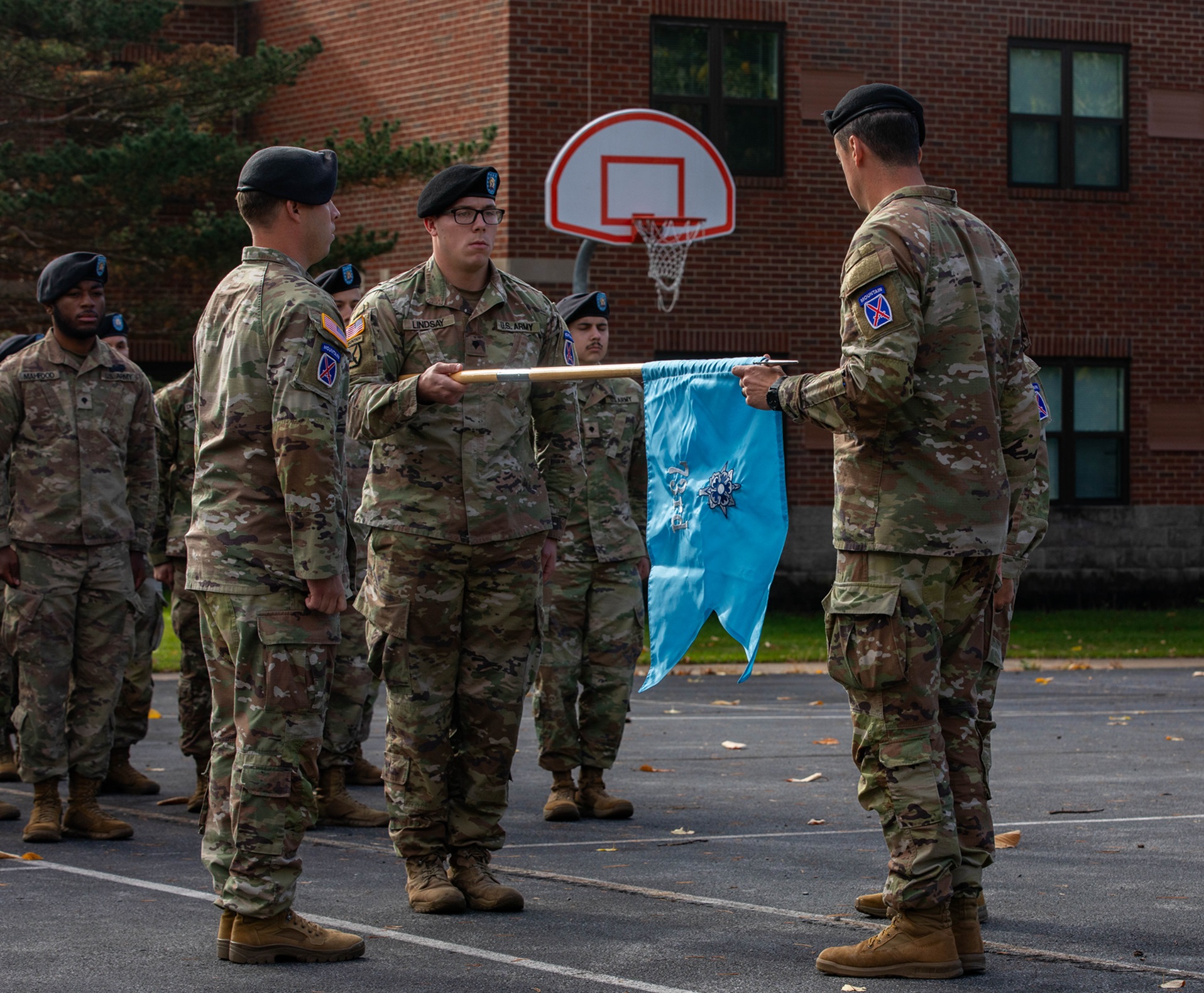 Soldiers unfurl a guidon during the 73rd GS MICO reactivation ceremony.