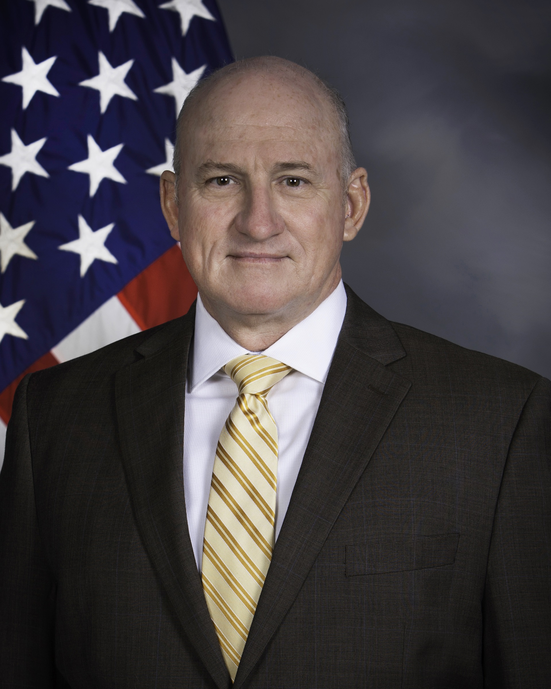Christopher Zimmer in front of U.S. flag.