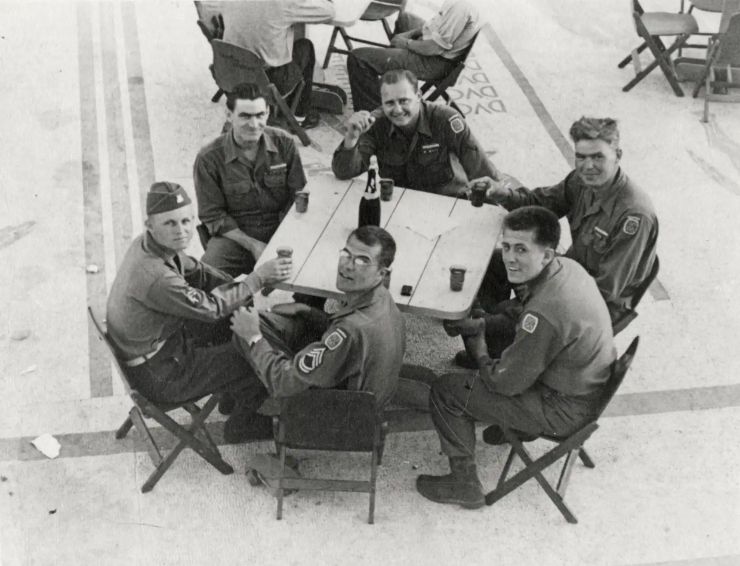 Soldiers sit outside at tables near Mussolinis Villa
