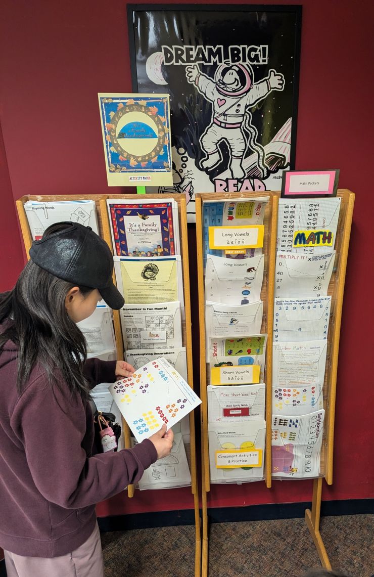 Woman looks at educational products at McEwen Library.