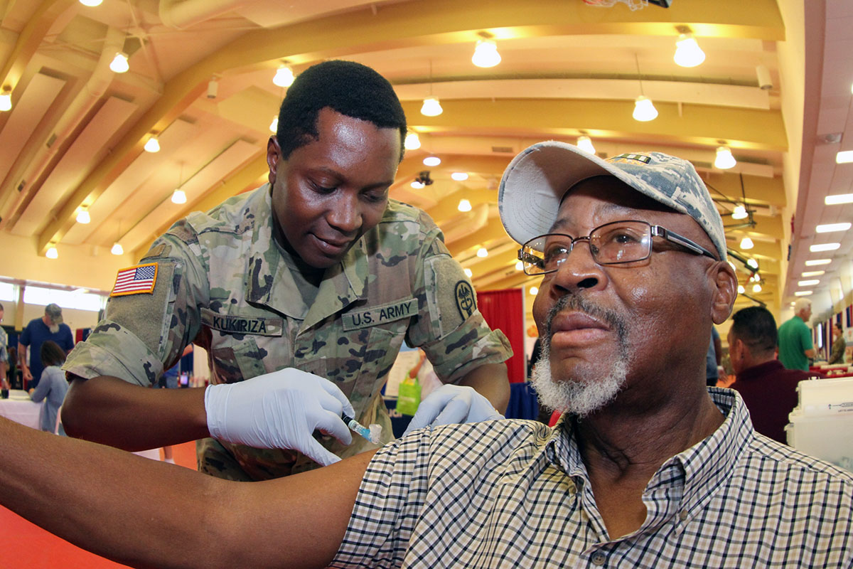 Photo of retiree receiving health care services from Soldier at Retiree Appreciation Day