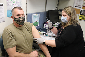 Photo: Garrison Commander Col. Michael D. Poss receives a COVID-19 vaccination Jan. 26, 2021, from Erica Miller, a registered nurse with the Fort McCoy Health Clinic, during the first round of COVID-19 vaccinations at Fort McCoy. Miller was the first to receive the vaccine on post