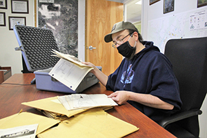 Photo: Fort McCoy Archaeologist Ryan Howell with the Directorate of Public Works Environmental Division Natural Resources Branch looks over old installation real property records Jan. 22 in a conference room at Fort McCoy.