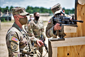 Photo: Staff Sgt. Christopher Upshaw, an observer-coach/trainer with the 181st Multi-Functional Training Brigade, instructs Pvt. James Curran, a cargo specialist with the 645th Inland Cargo Transport Company on how to find a comfortable standing supported firing position with an M249 during preliminary marksmanship instruction July 10 for Pershing Strike 21 training operations at Fort McCoy.