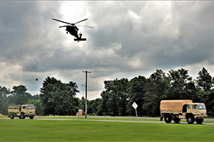 Photo: A UH-60 Black Hawk helicopter flies overhead and other training operations are shown July 15, 2021, at Fort McCoy, Wis., for the Army Forces Command Exercise Pershing Strike ’21.