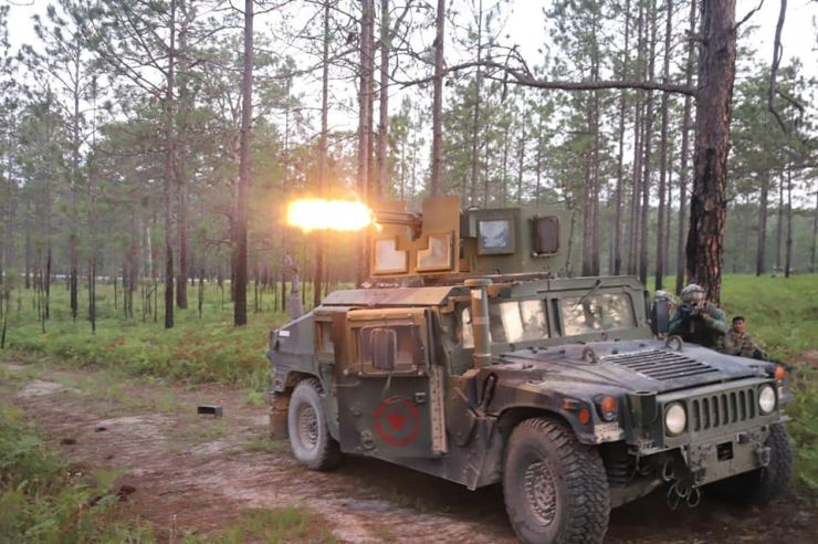 An up-armored HMMWV suppresses the enemy from maneuvering.