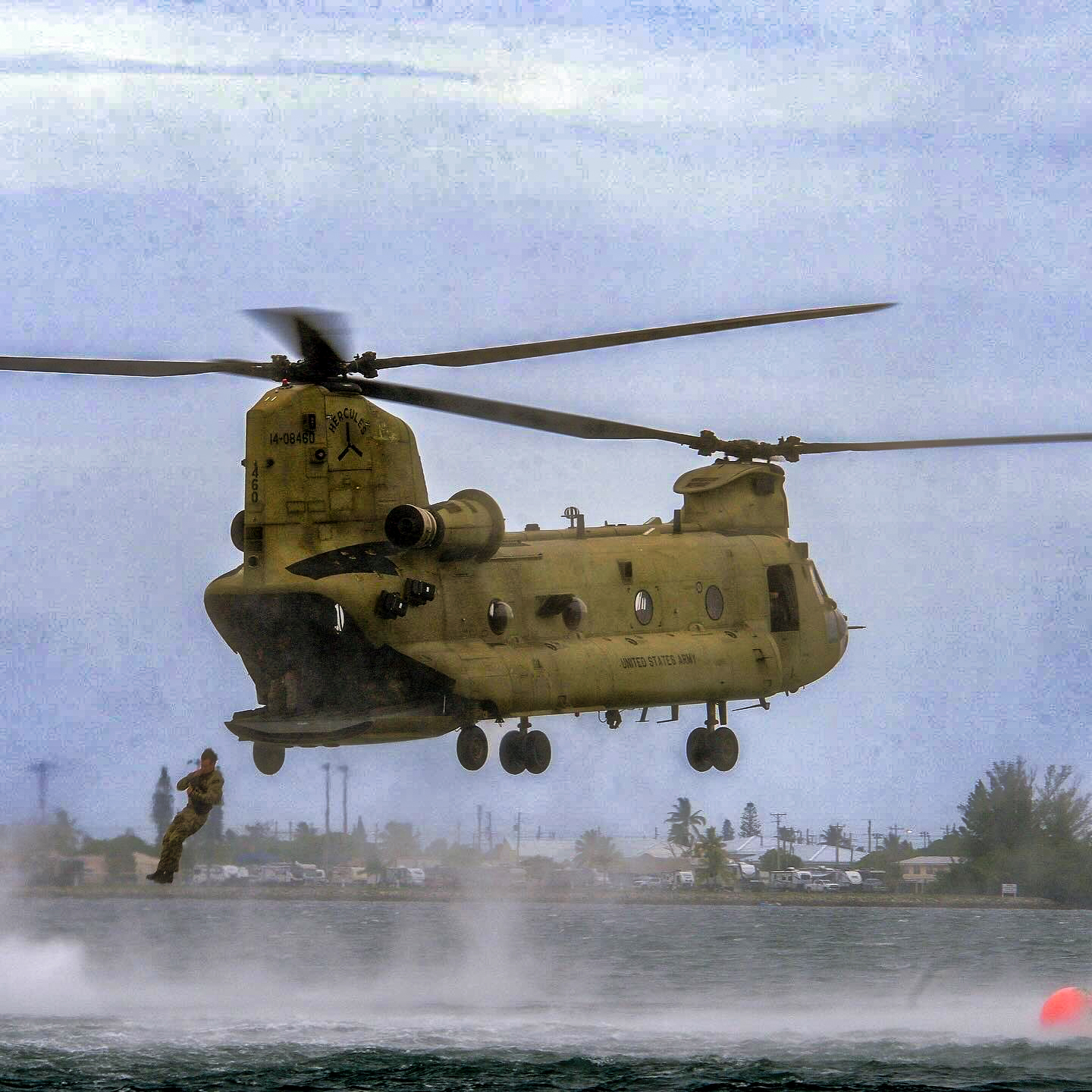 CH-47 Chinook helicopter hovers above water while Soldiers are jumping in the water