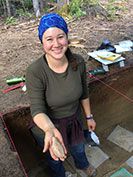 A graduate student holds a broken bison leg bone.