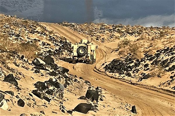 A mine-resistant, ambush-protected vehicle gets stuck while attempting to traverse a semi-improved trail at NTC.